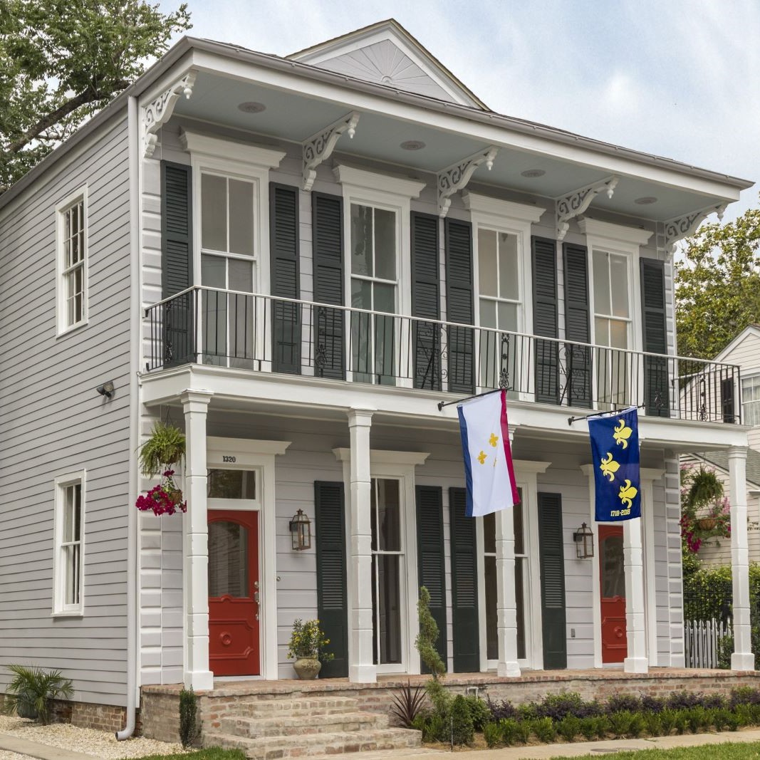 1320 double-gallery home Uptown New Orleans flying New Orleans city and Acadiana flags — sold by Patrick Knudsen