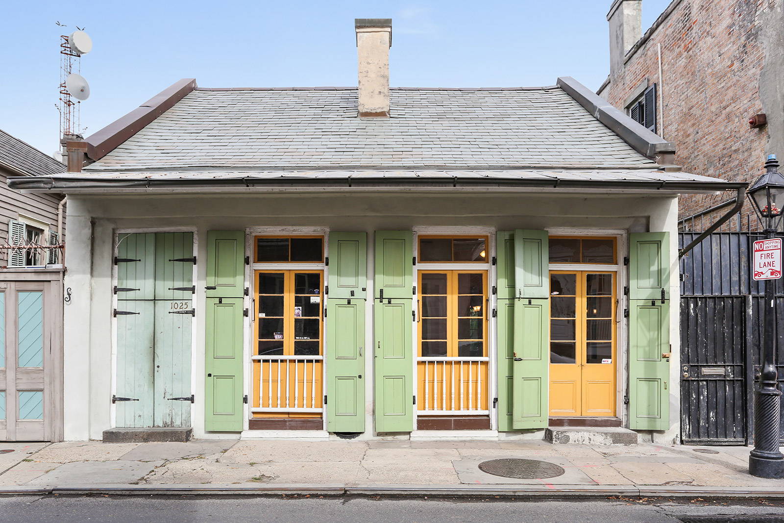 1025 Creole cottage French Quarter yellow doors light green shutters — sold by Patrick Knudsen New Orleans